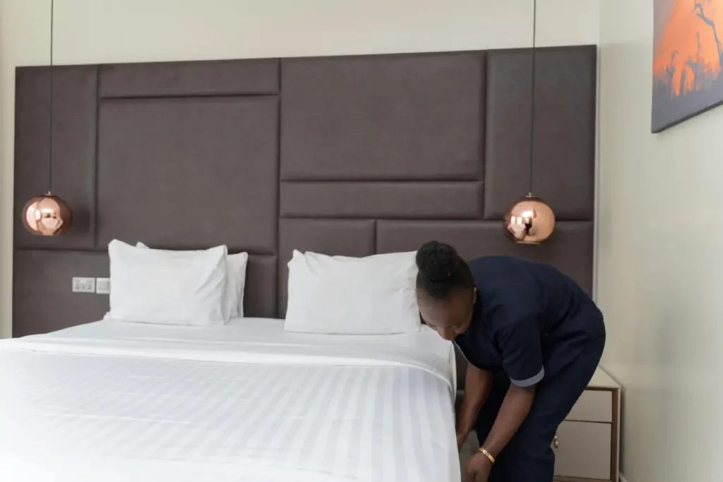 Hotel Staff Making Bed in Modern Room